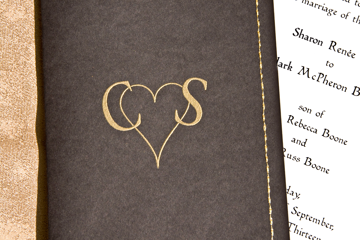 Hand embossed custom logo in gold on black cardstock